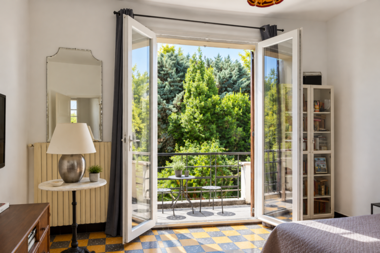 Chambre lumineuse avec portes-fenêtres ouvertes