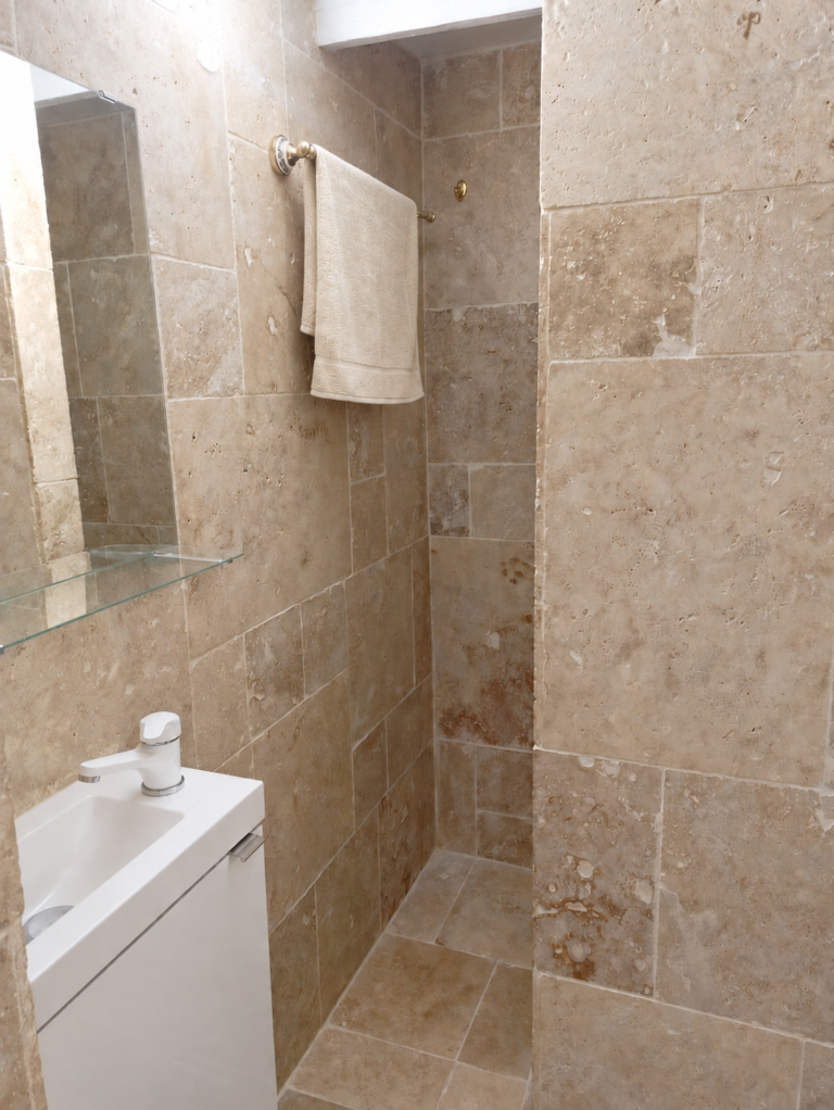 Salle de bain en travertin avec serviette crème